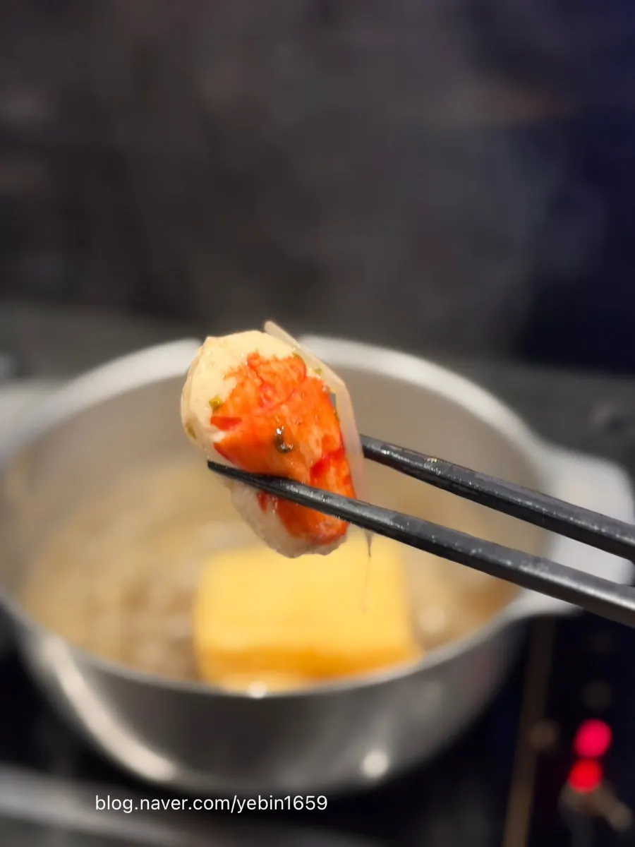 A piece of shabu-shabu meat dipped in sauce