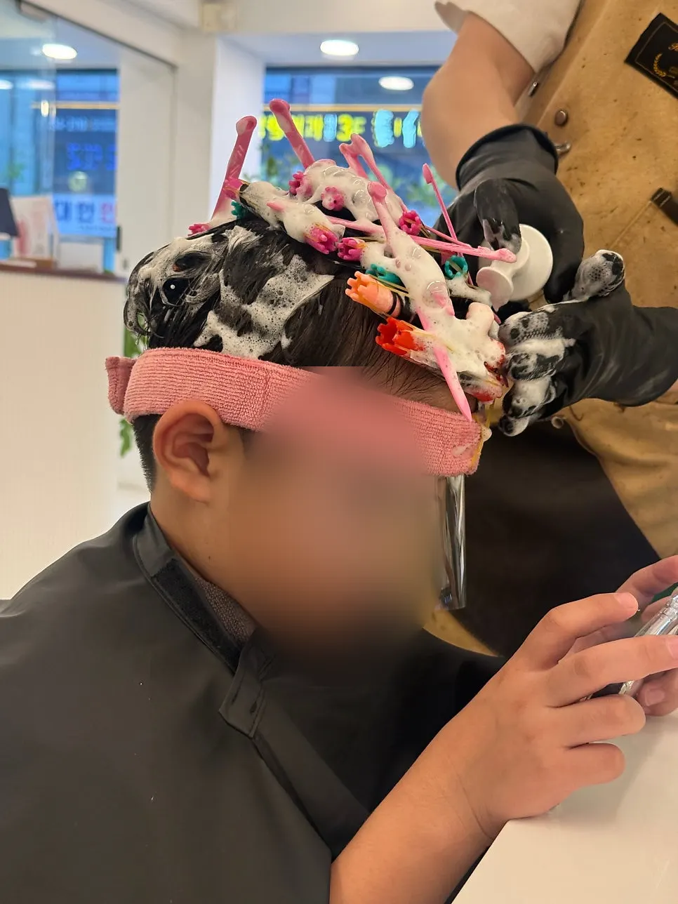 Back view of the child's hair with perm rods in