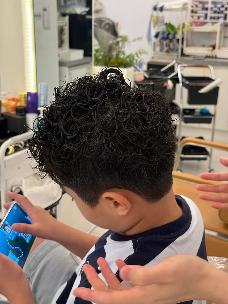 The designer checking the perm's progress