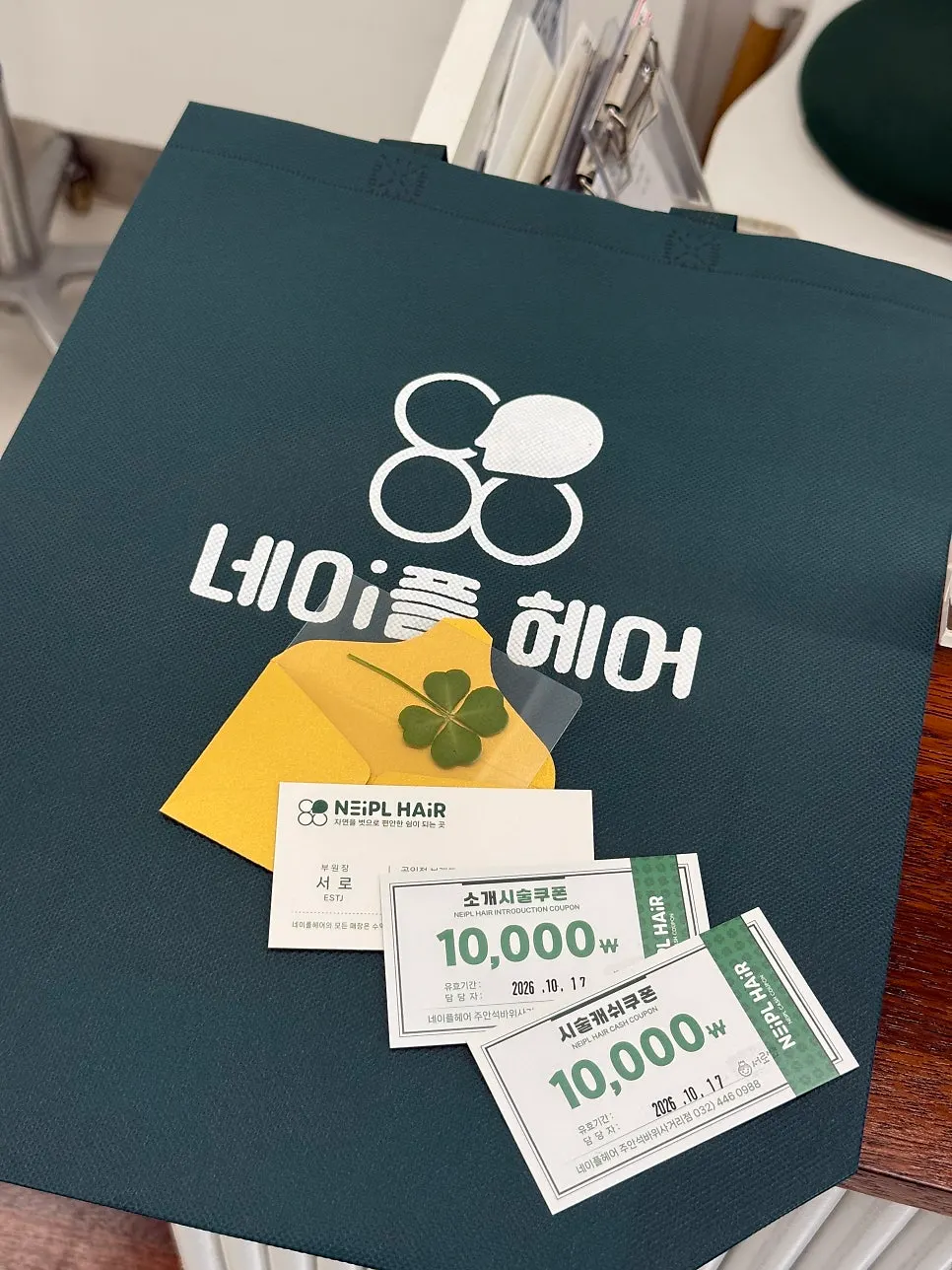 A four-leaf clover, coupons, and an eco bag received as gifts