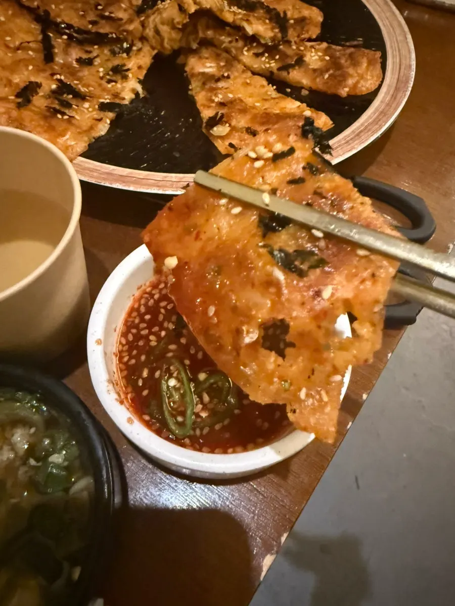 간장 양념장에 찍어 먹는 김치전 한 조각
