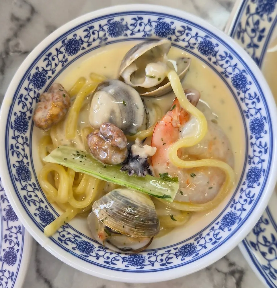 Lifting noodles from the cream jjamppong bowl