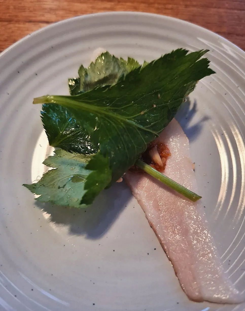 A piece of chilled pork jowl being picked up
