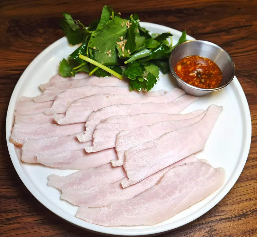 A plate of chilled pork jowl with seasoned chamnamul salad