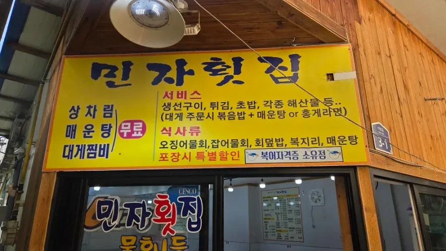 상차림비 무료와 서비스 안내가 적힌 민자횟집 안내판