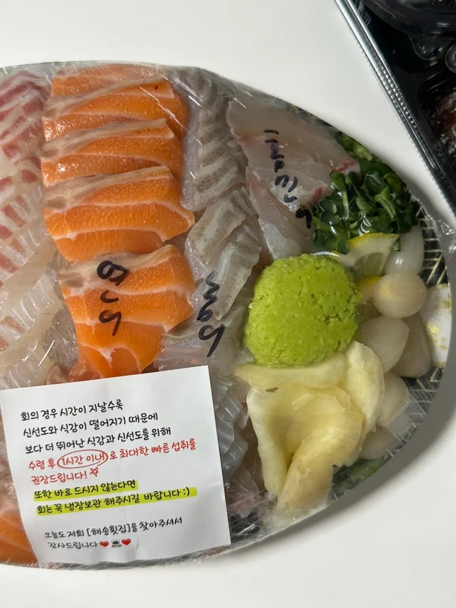 Hand-written labels of sashimi types on the packaging