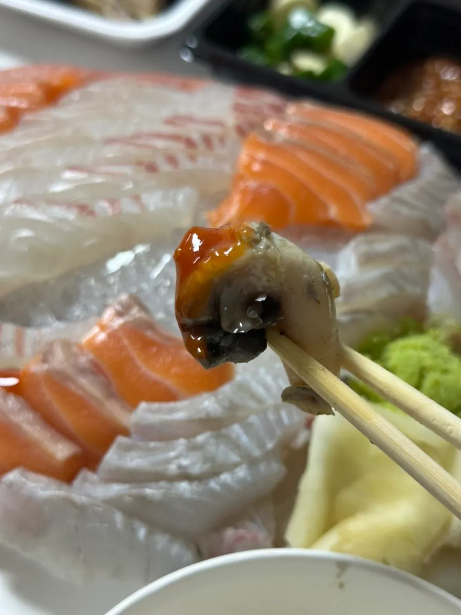 Whelk dipped in chili sauce