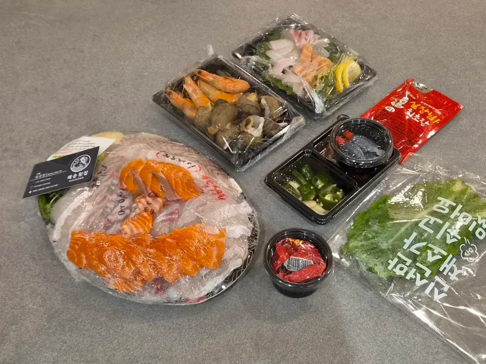 Plastic wrap on the sashimi platter labeled with the names of each fish