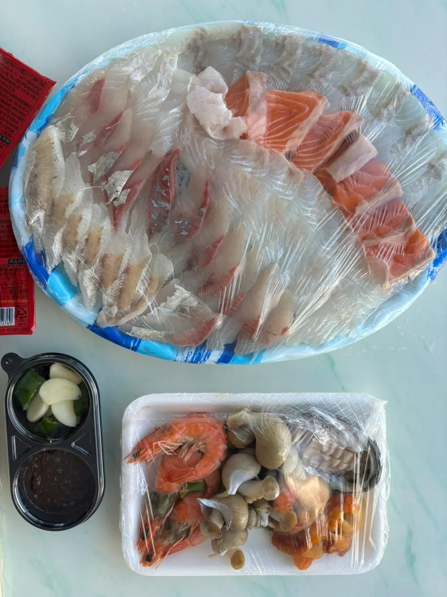 Opening the mixed sashimi takeaway container at our lodging