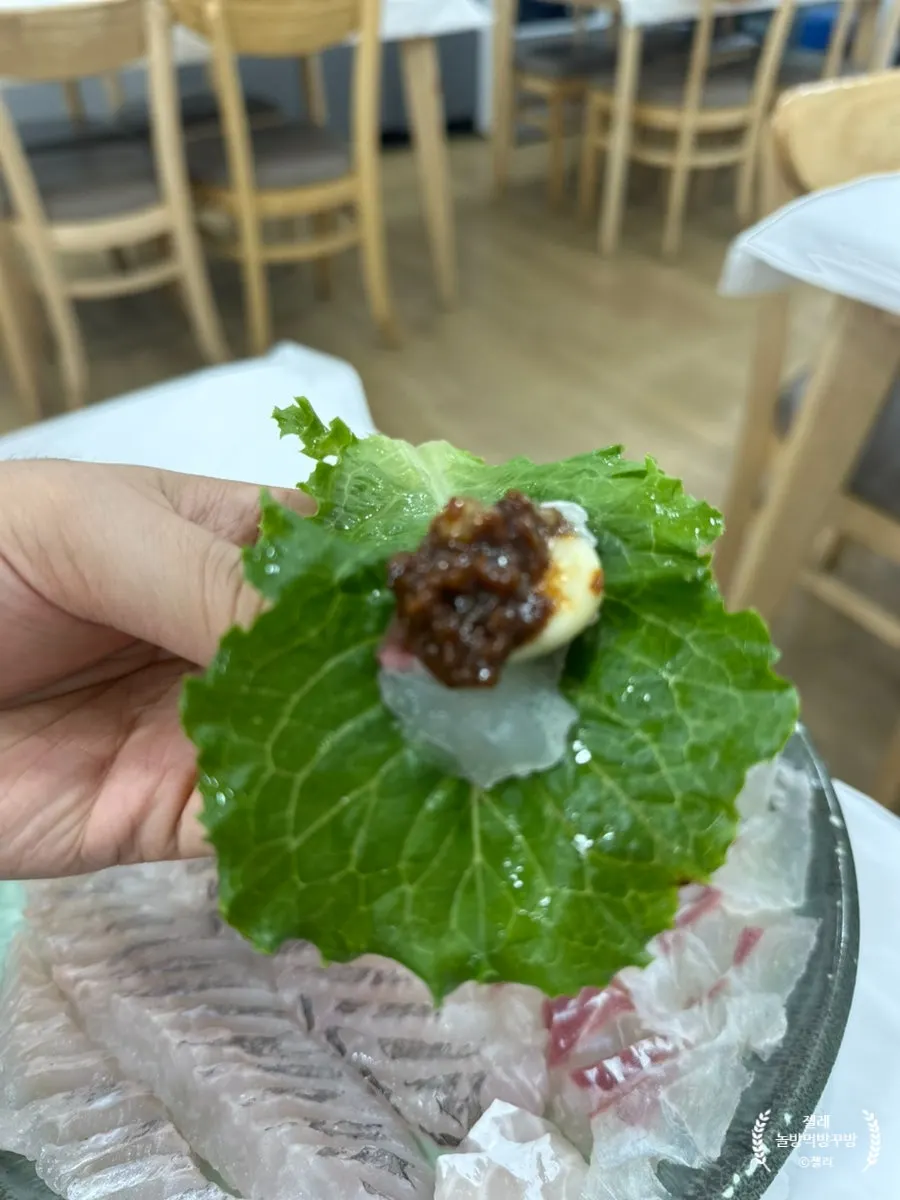 A piece of sashimi dipped in ssamjang and chojang