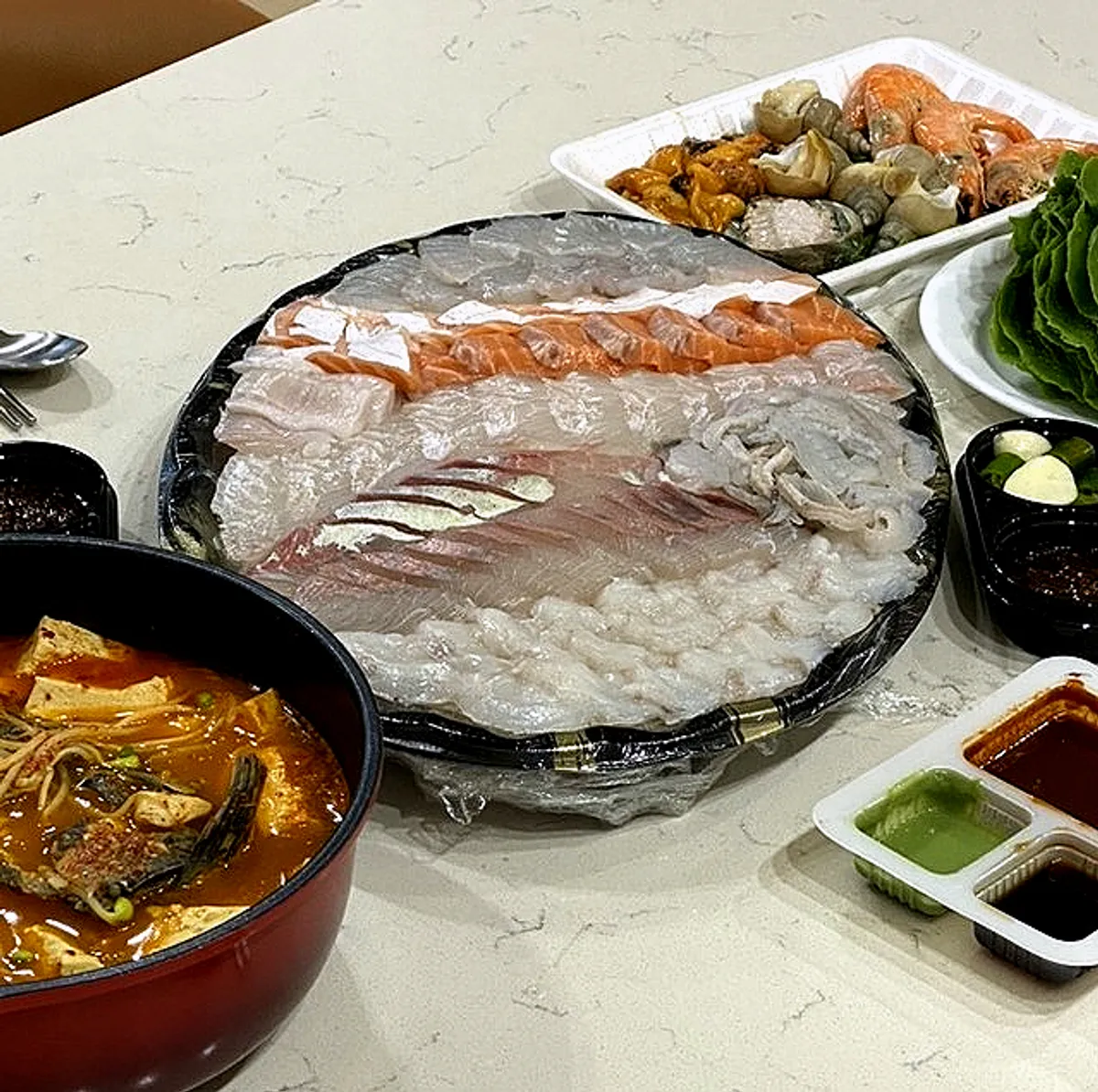 Main photo of Minja Hoetjip's mixed sashimi platter and spicy fish stew