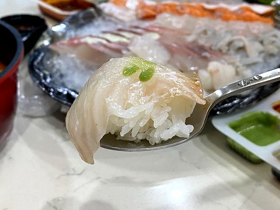A piece of olive flounder belly sashimi