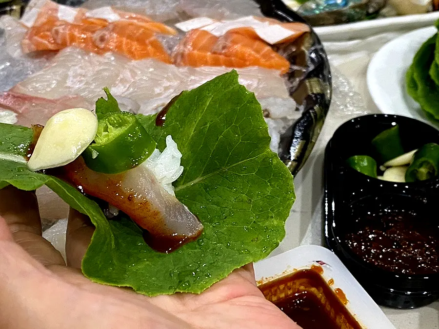 Sashimi being wrapped in vegetables