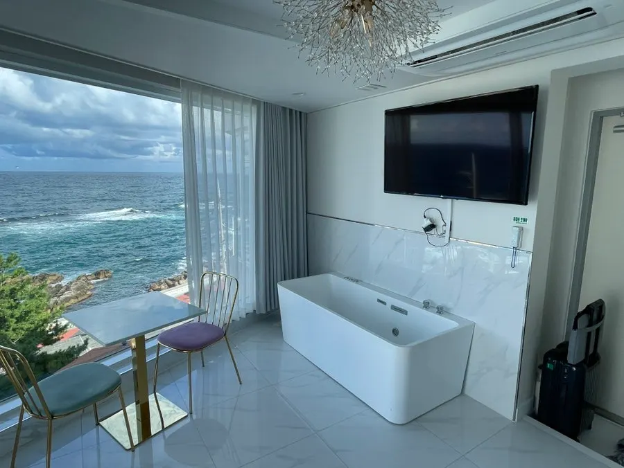 Bed and sofa in front of the floor-to-ceiling window