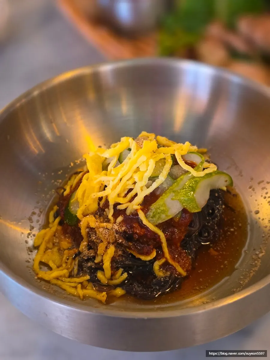 A spoonful of bibimbap topped with meat