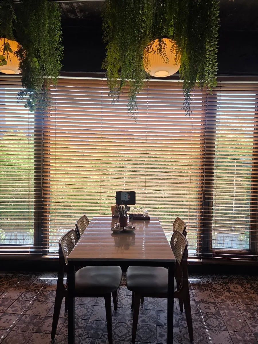 Korean bar interior contrasting a folding screen with modern tables