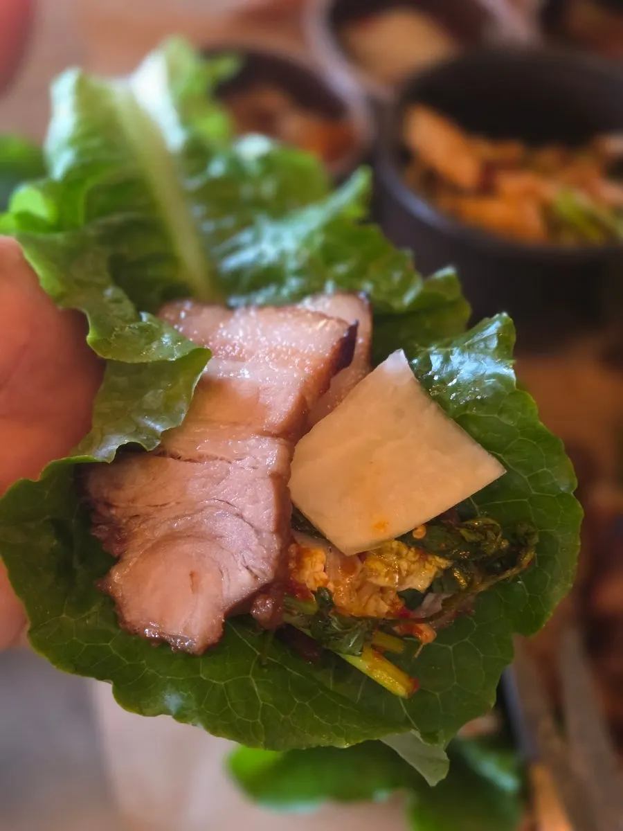 Sliced yangnyeom galbi with a bite of cold noodles