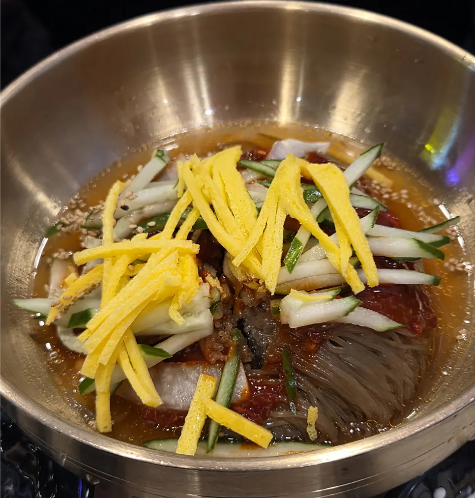 Two bowls of mul naengmyeon and bibim naengmyeon