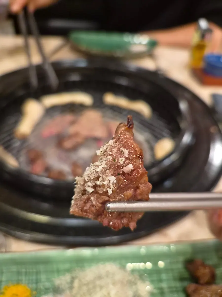 A piece of grilled sirloin dipped in perilla leaf salt