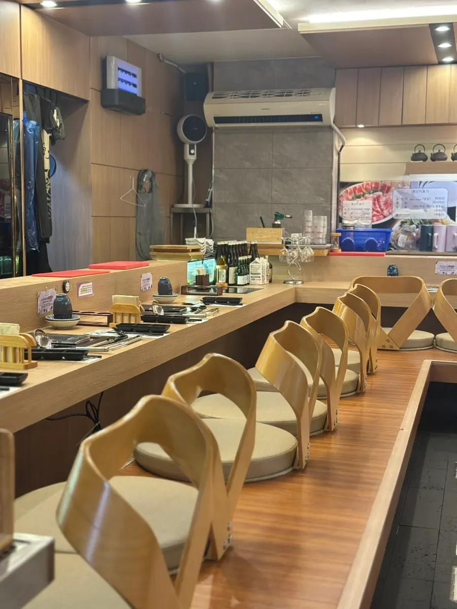 A room at Hana Shabu Shabu fitting two four-person tables