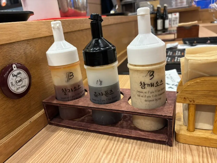 다찌석에 세팅된 반찬과 샐러드, 소스