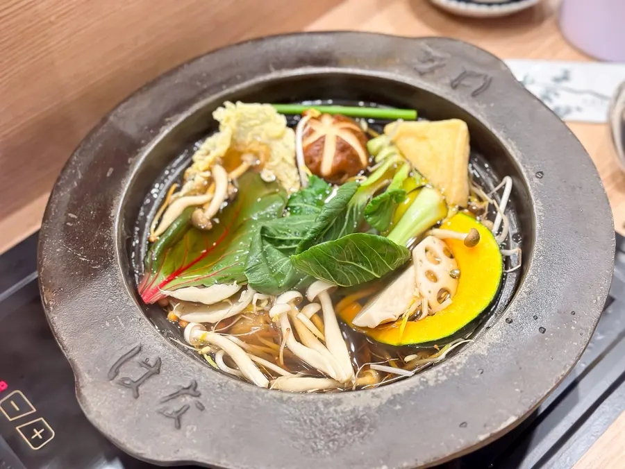 A tray of mushrooms and vegetables for shabu-shabu