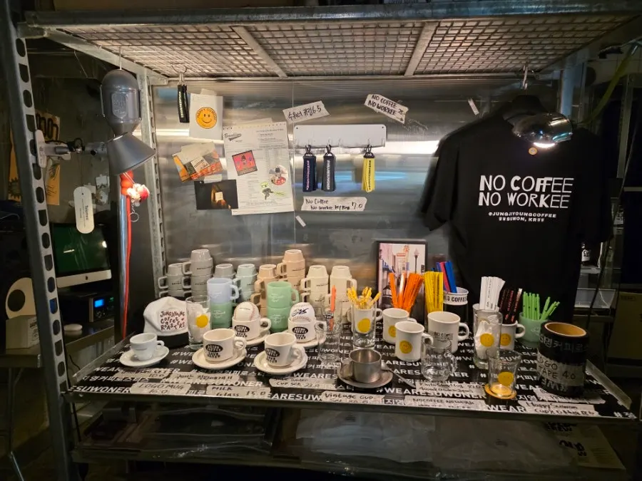 Kệ trưng bày hạt cà phê và drip bag ở một góc quán