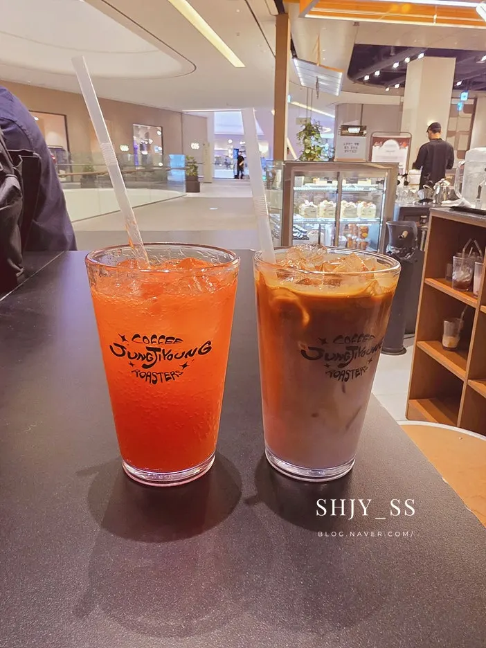 Two glasses: iced café latte and grapefruit ade