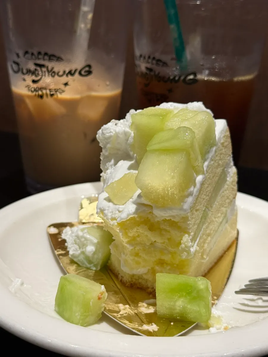 Pastel de melón junto a un latte helado sobre la mesa