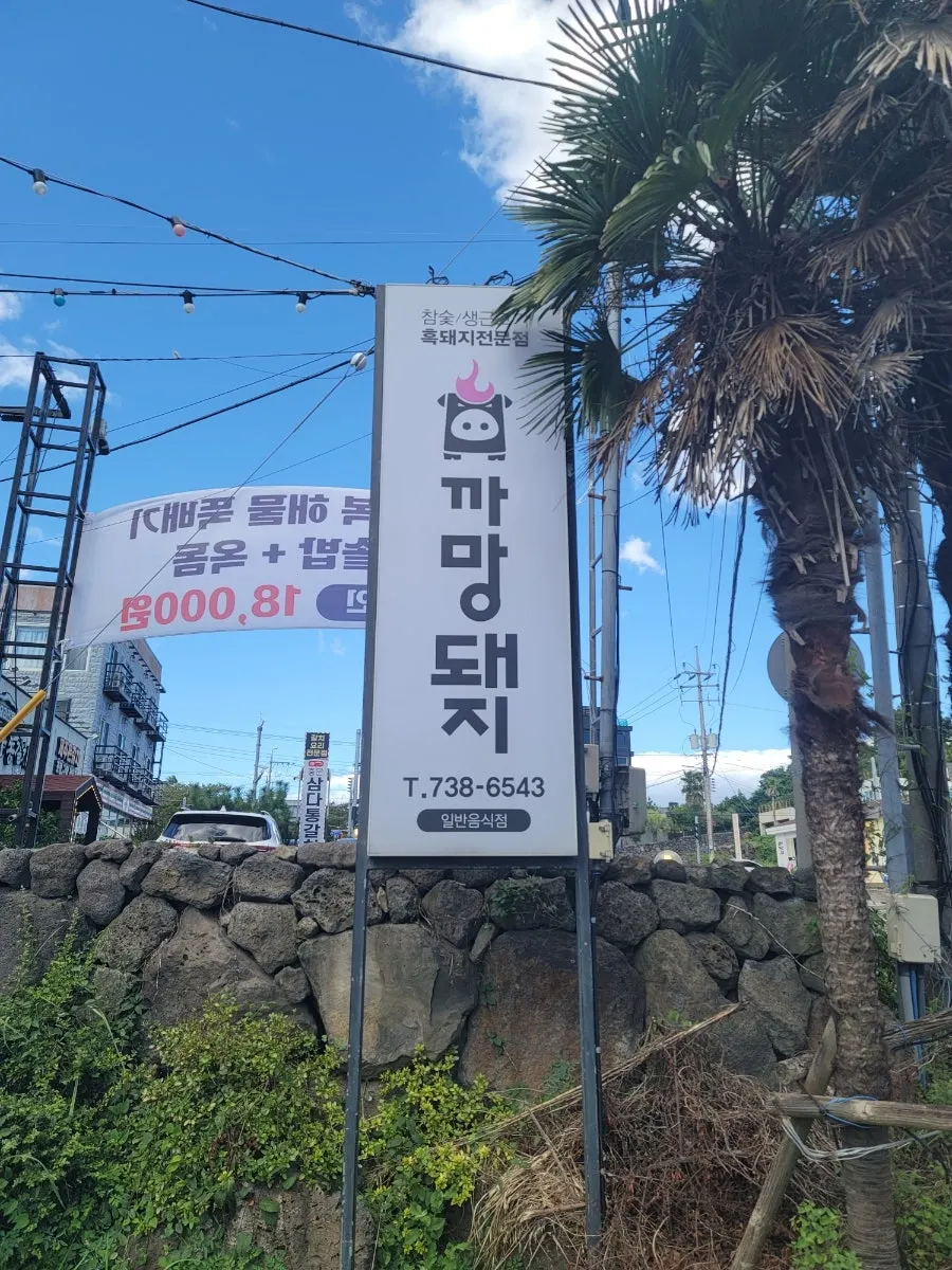 Standing sign for Kkamang Dwaeji Jungmun Branch by the roadside