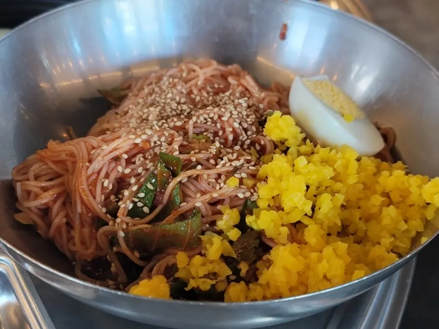 Bibim guksu topped with danmuji and boiled egg