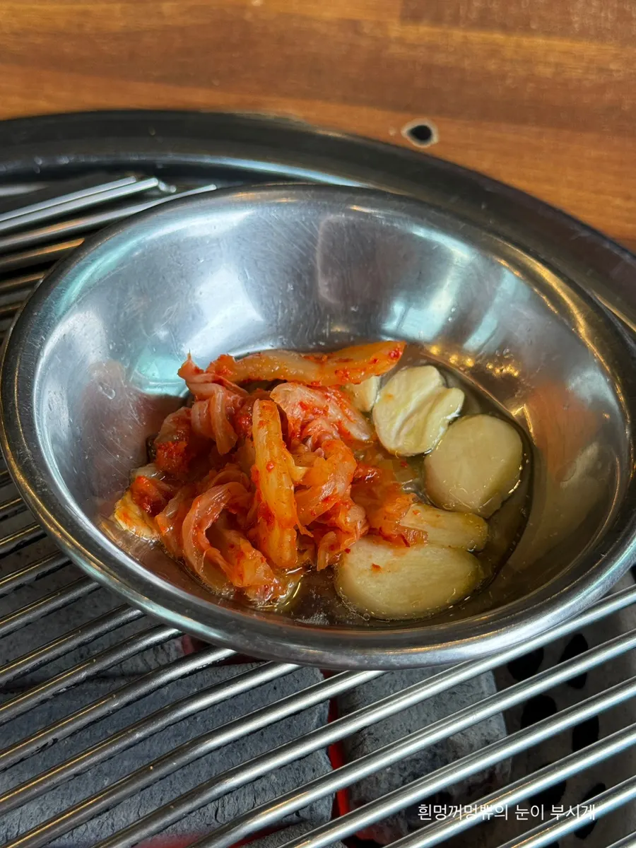Garlic and kimchi grilling in pork fat on the grill