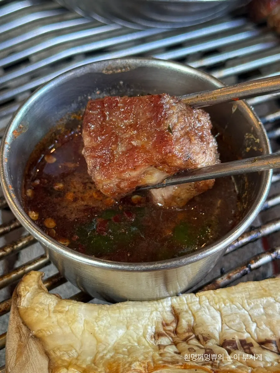 A piece of black pork neck dipped in myeoljeot