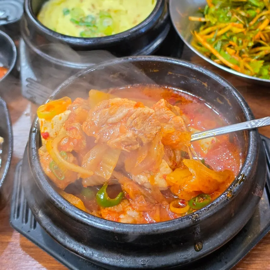 두툼한 고기가 가득한 김치찌개 한 숟갈