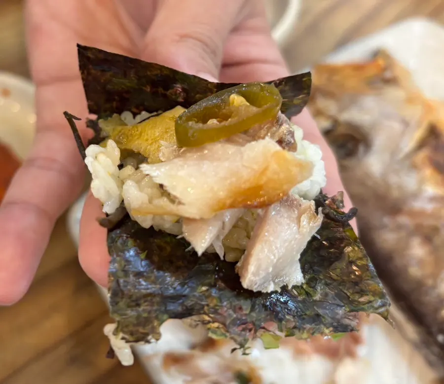 Rice wrapped in seaweed with a piece of grilled tilefish