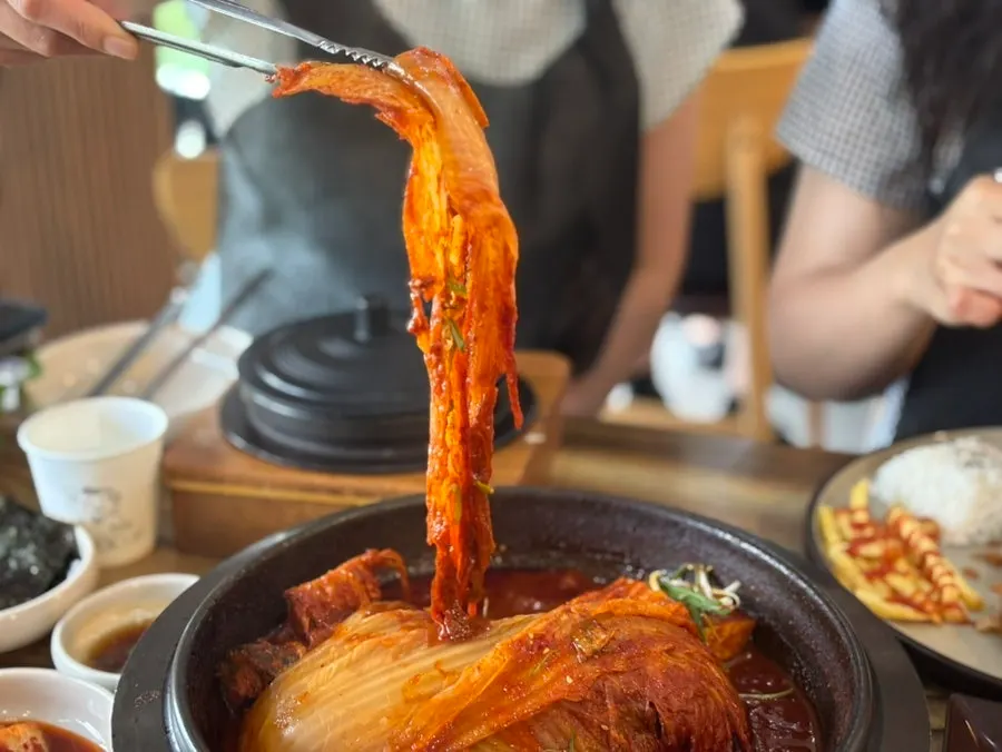 Pot of mackerel kimchi stew topped with old kimchi