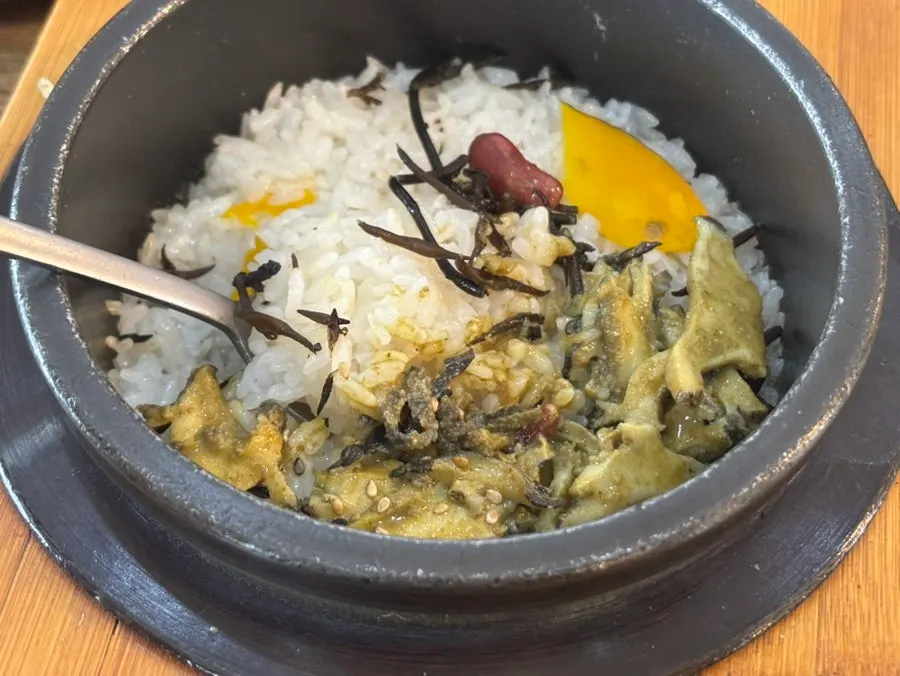 A piece of mackerel on top of old kimchi ready for wrapping