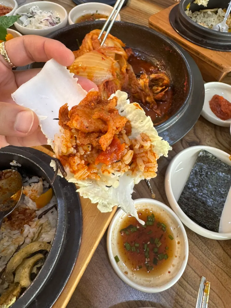 A cabbage wrap piled with rice, pork bulgogi, and old kimchi