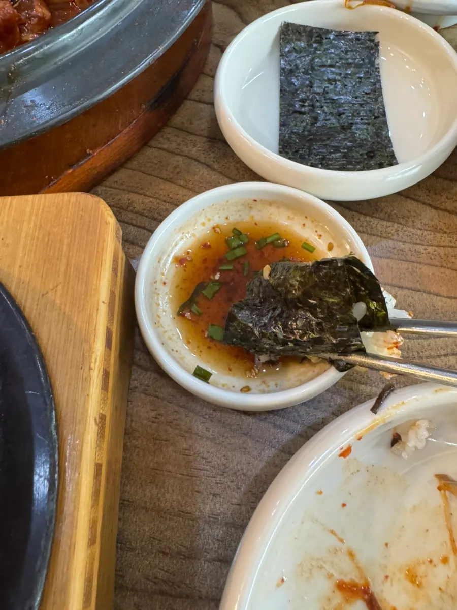 Hot stone rice wrapped in gim and dipped in seasoning sauce