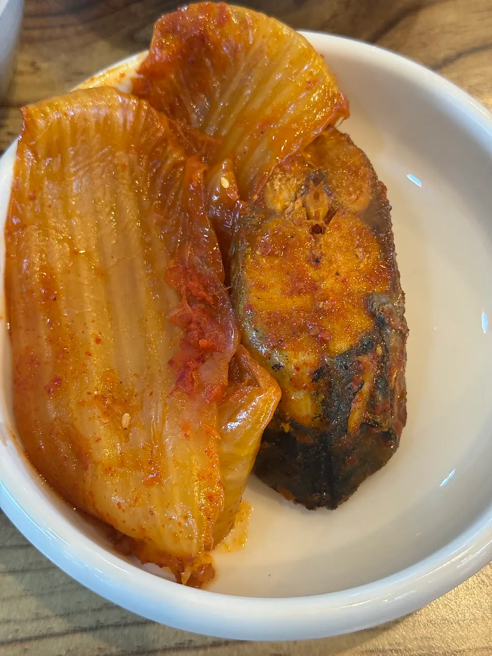 A large chunk of mackerel underneath the old kimchi
