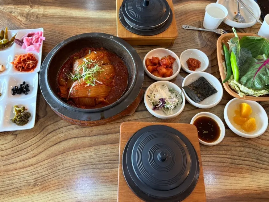 Table spread of old kimchi mackerel ssam-bap and abalone hot pot rice