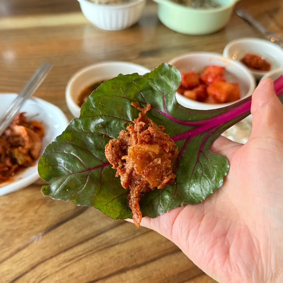 A spoonful of rice topped with mackerel and old kimchi
