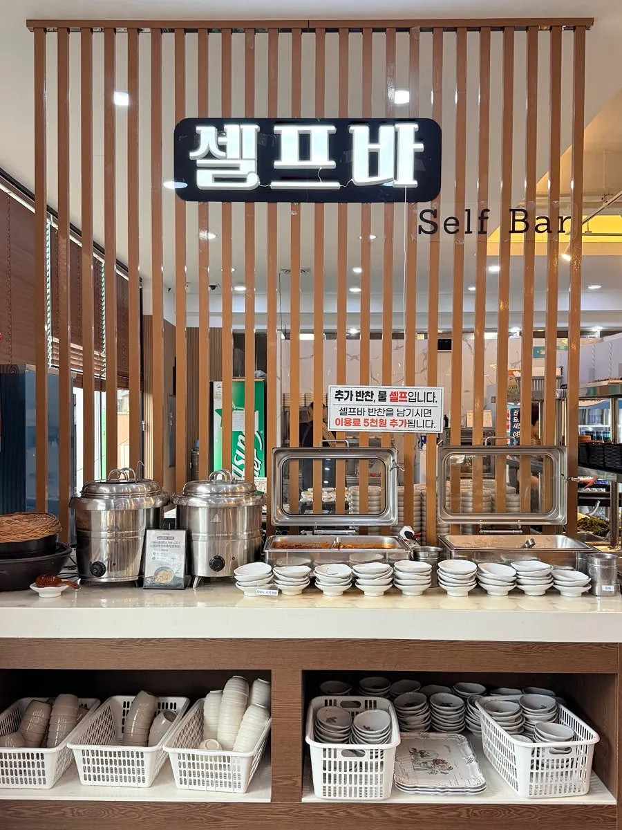 The self-serve bar corner with 16 banchan laid out