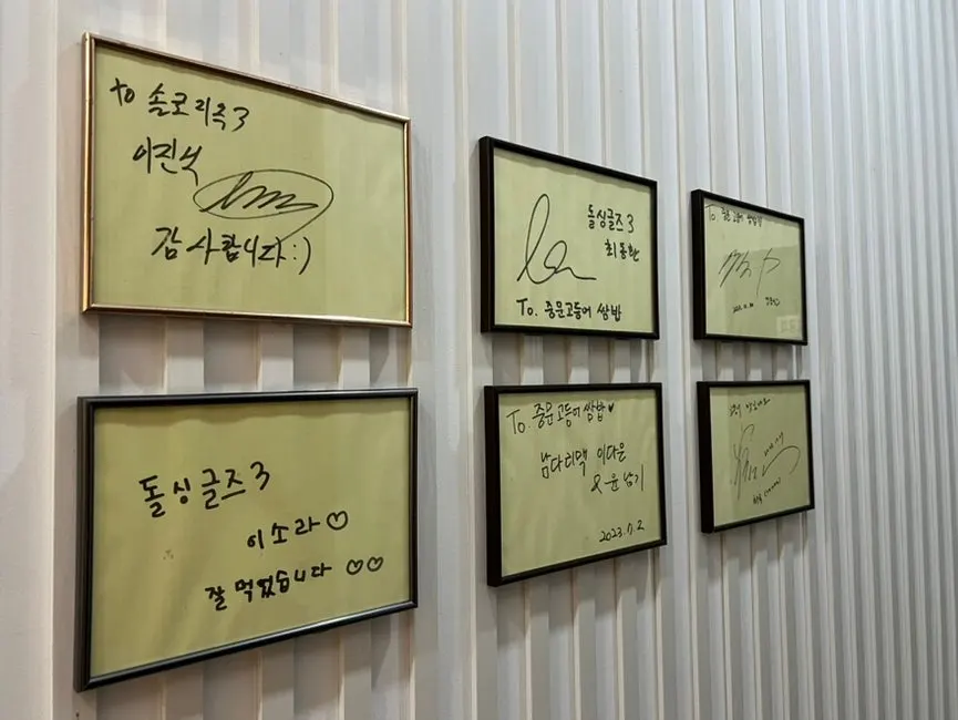 Hallway wall at Jungmun Godeungeo Ssam-bap covered in autographs