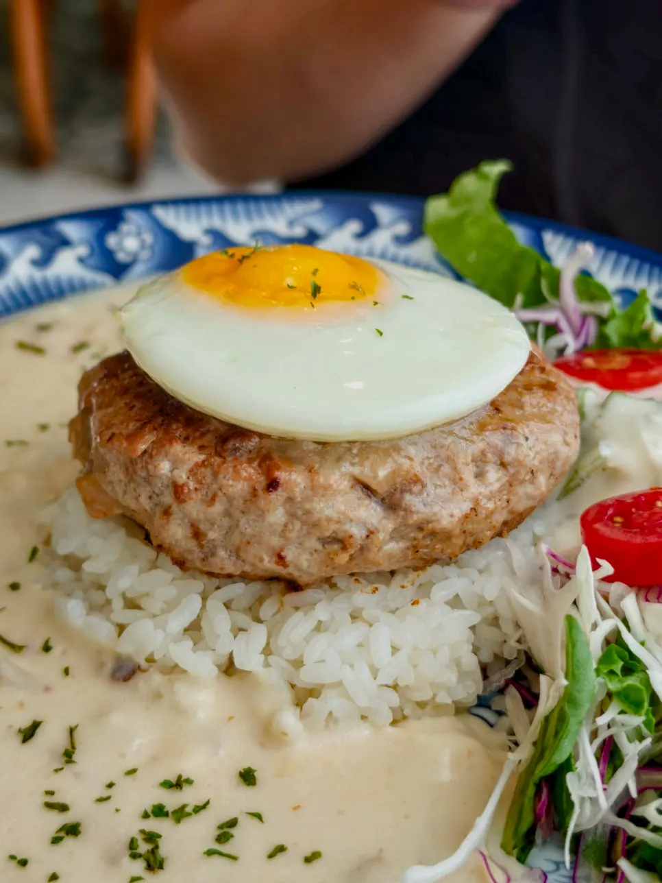 Plate of garlic cream hambak topped with a hand-made patty