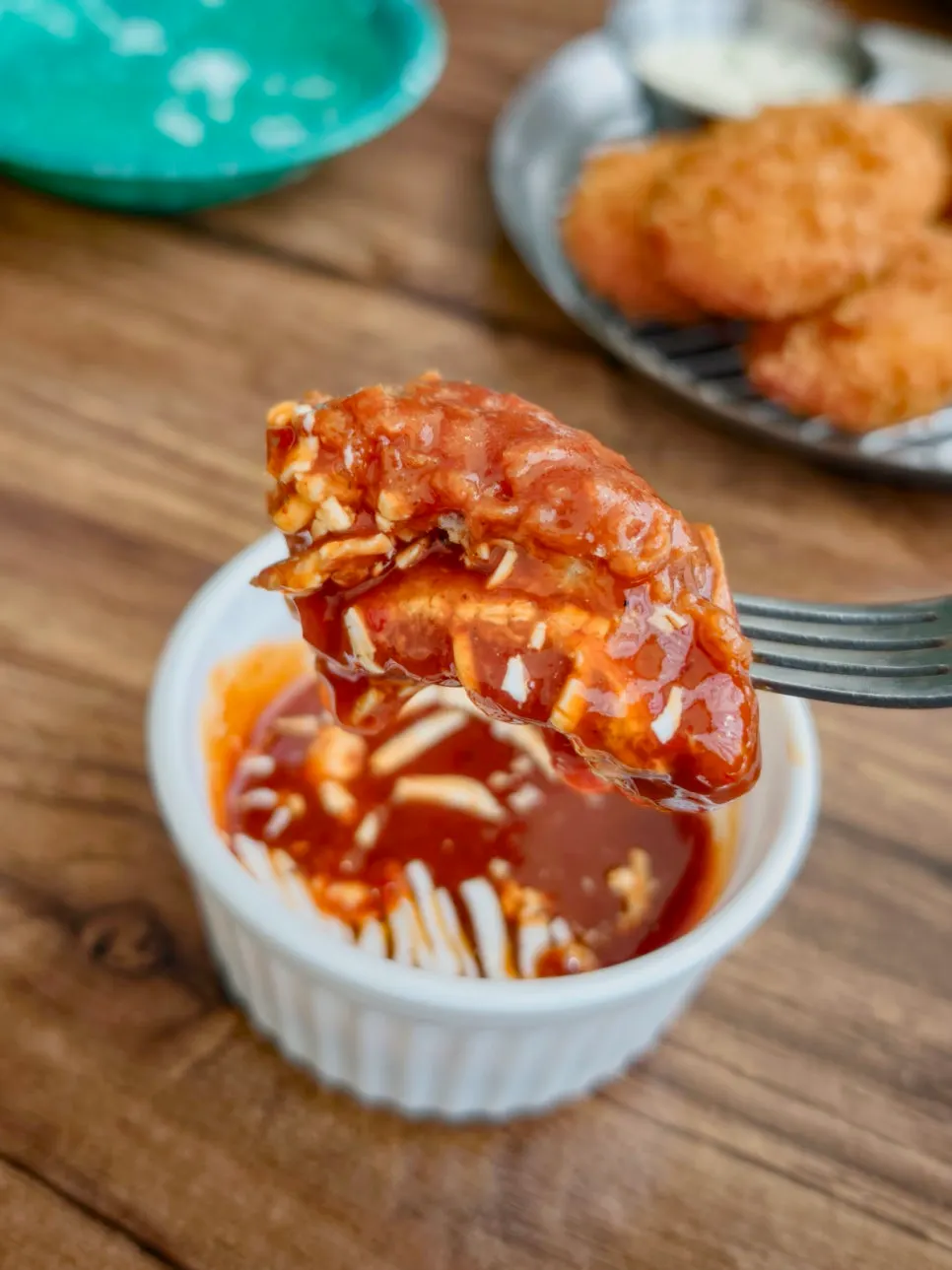 A bite of pork cutlet dipped in spicy sauce