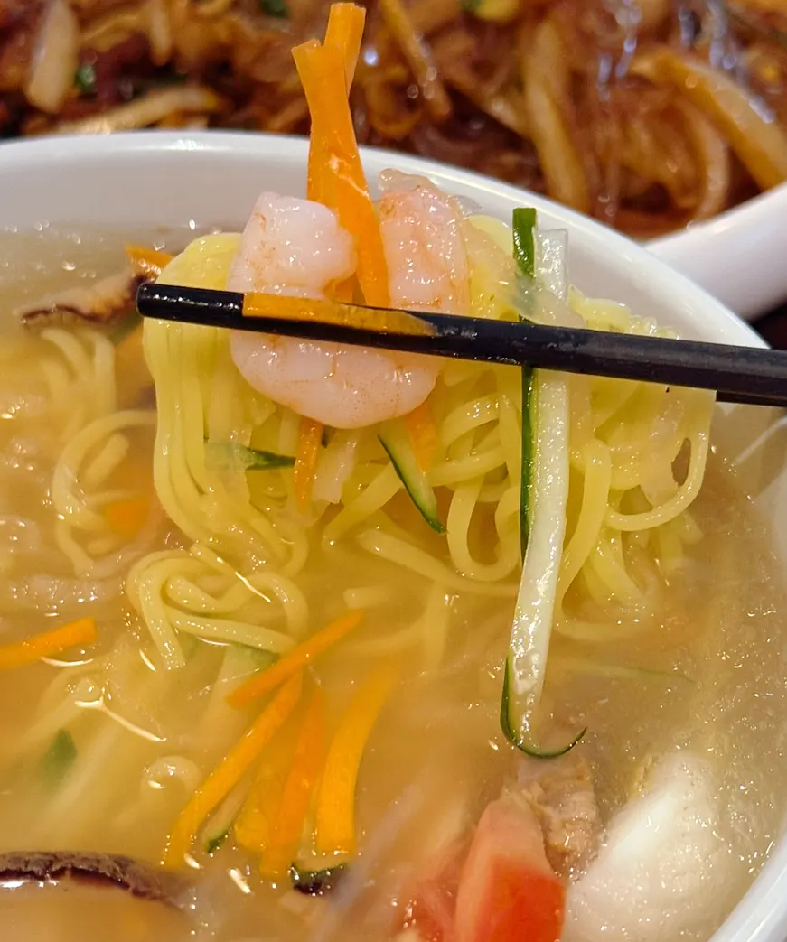 Noodles lifted with chopsticks from the jungwa naengmyeon
