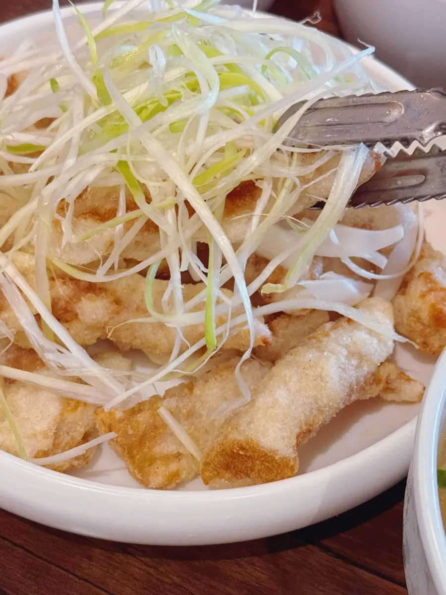Cross-section of sweet and sour pork paired with green onion strips