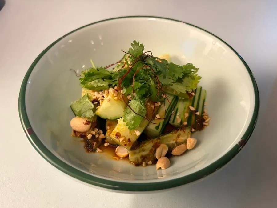 A plate of cucumber salad topped with cilantro