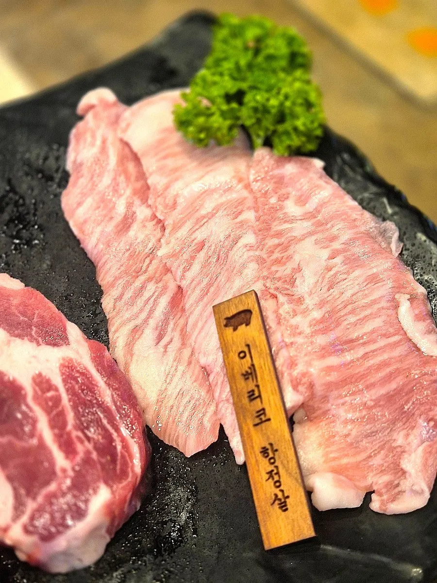 Iberico pork jowl cooking over charcoal